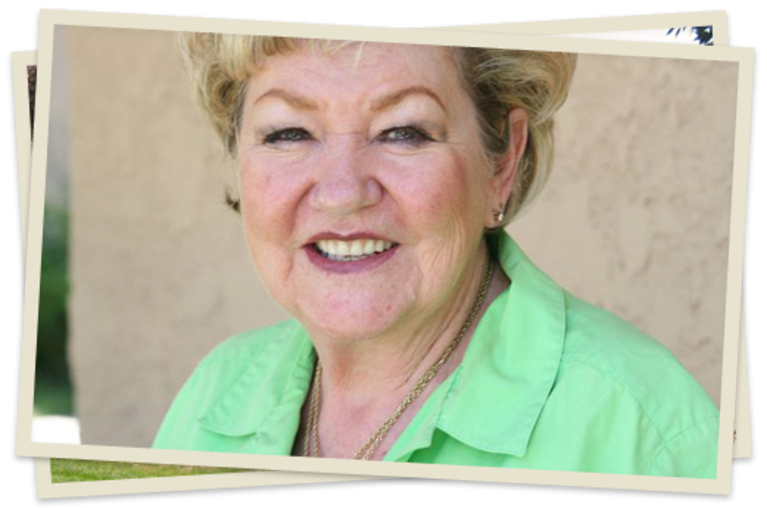 A woman in green shirt smiling for the camera.