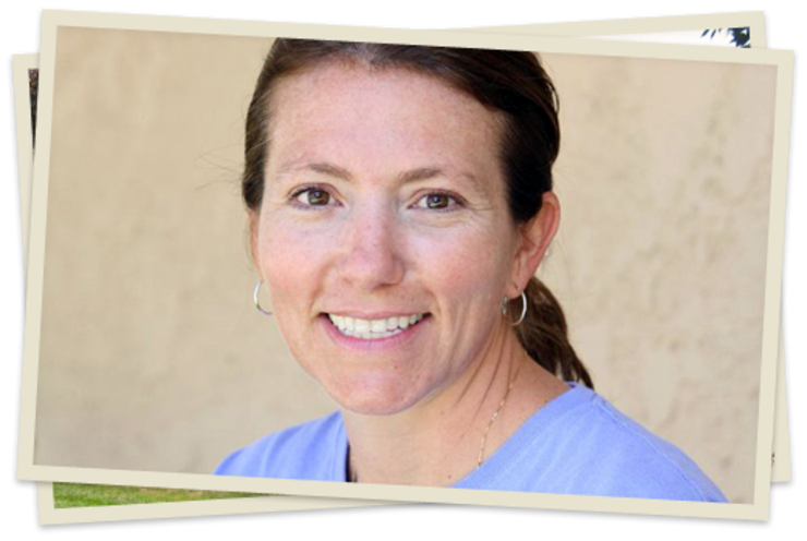 A woman with brown hair and blue shirt smiling.